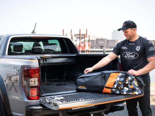 mand sætter stihl timbersports motorsavstaske på ladet af en bil