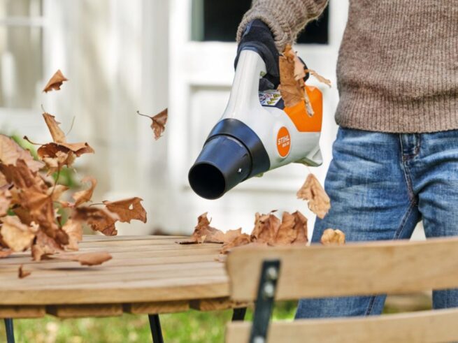 kvinde blæser blade af havebord med stihl løvblæser bga 30