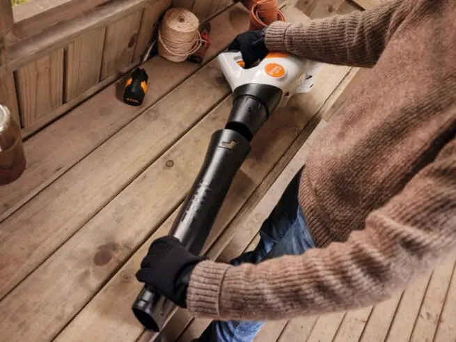 kvinde afmonterer blæserøret på en stihl løvblæser bga 30