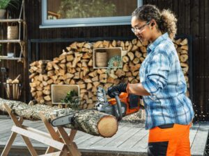 kvinde skærer brænde med husqvarna batterimotorsav 230i